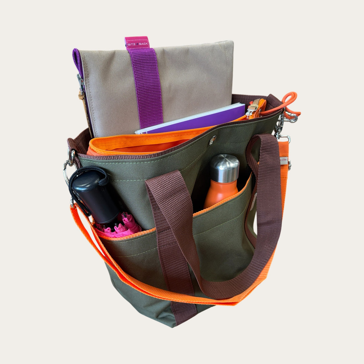 Horsebag oliv mit orange, geöffnet mit herausnehmbarem Innensack, Trinkflasche und Schirm in den Außenfächern