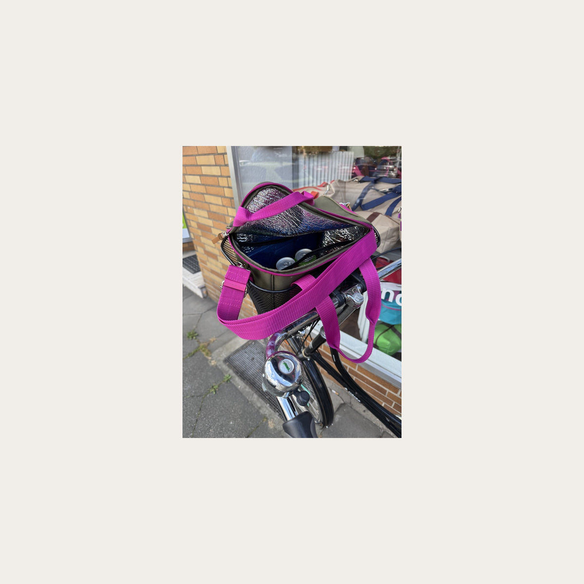 Kleine Kühltasche oliv mit magenta, geöffnet im Fahrradkorb